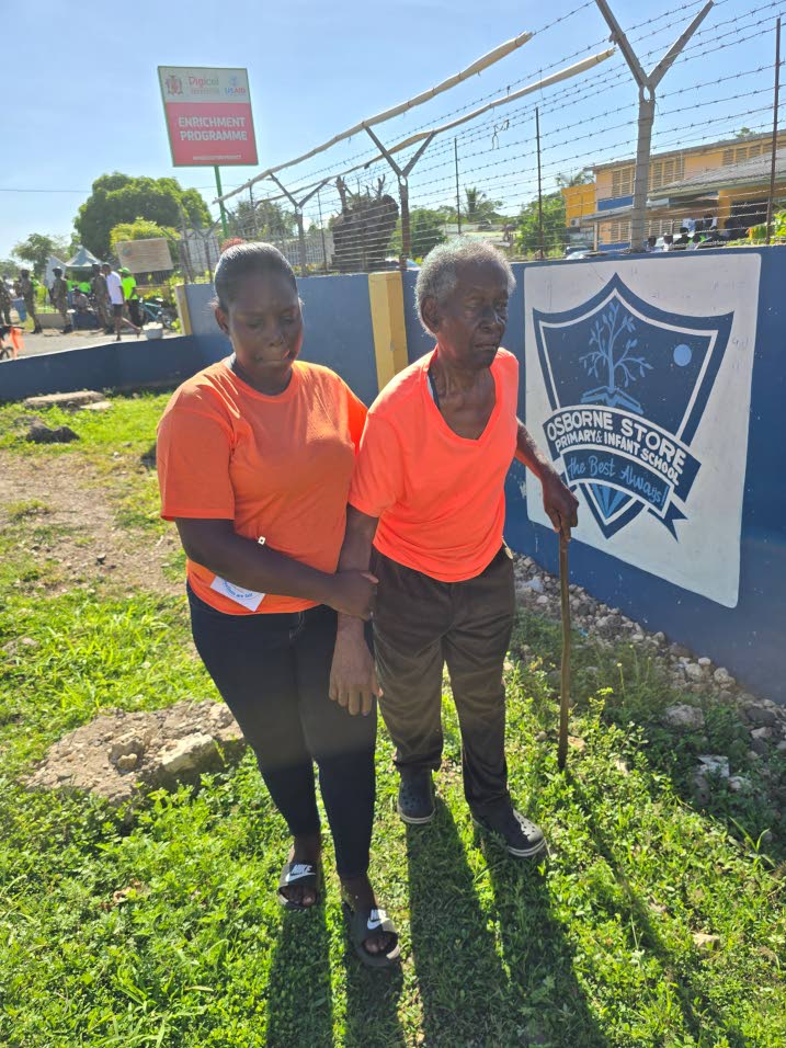 Shericka Pinnock helps her uncle, Winston Pinnock, to the polling station at Osborne Store Primary School in Clarendon on election day, September 3, 2025.Photo: Karl Mclarty
